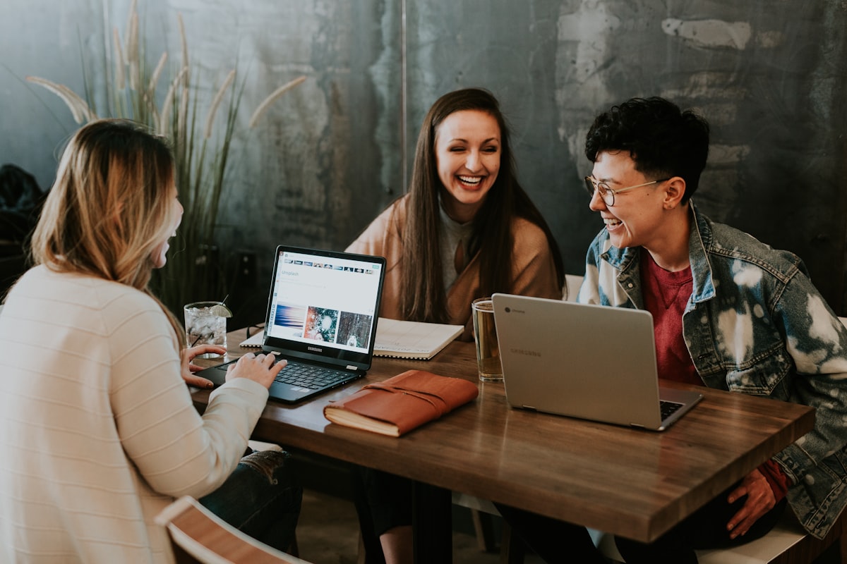 Team collaborating around a laptop in a bright workspace