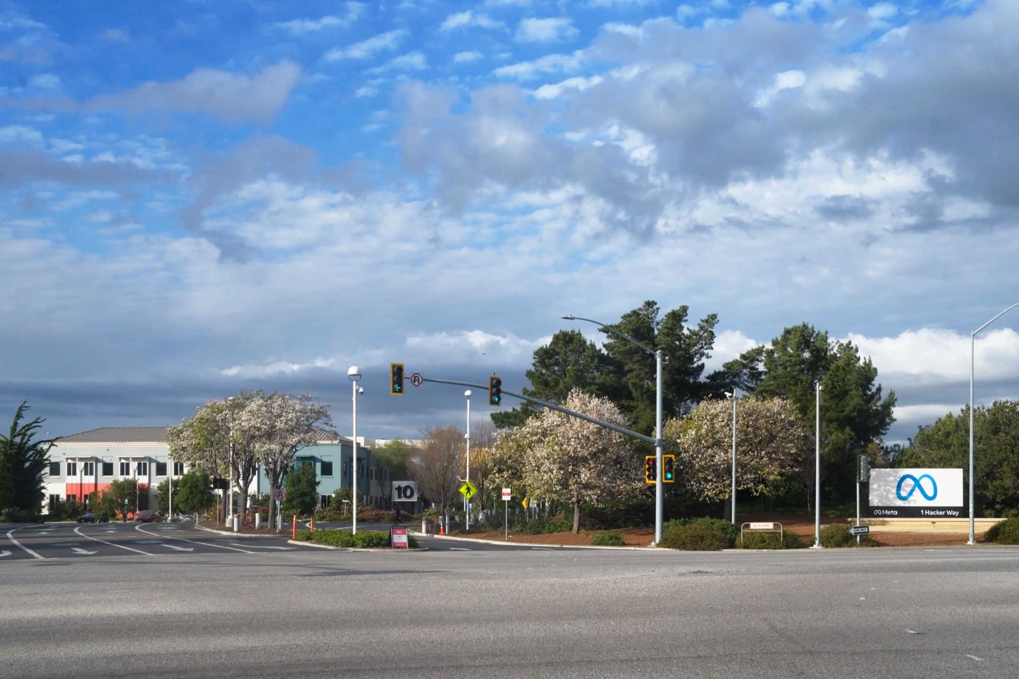 Entrance to Meta's headquarters campus in Menlo Park, with the infinity logo beside the road