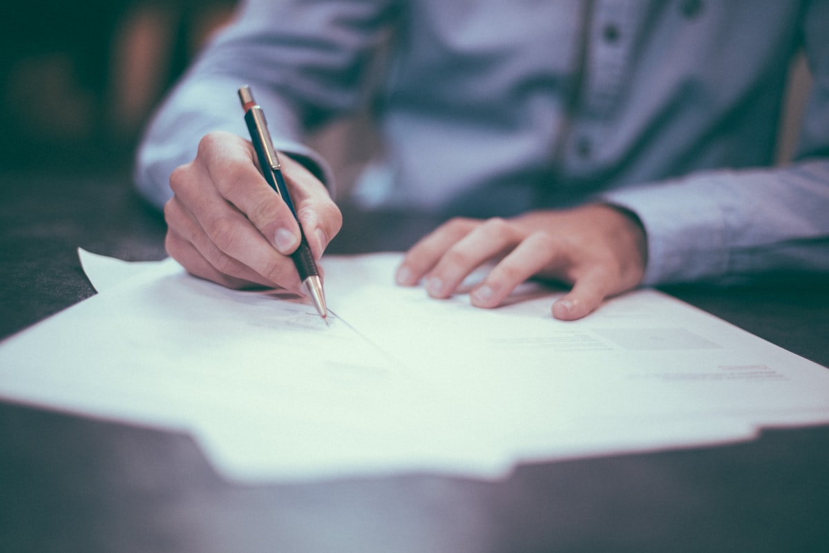 Hands reviewing retirement paperwork and a calculator on a wooden desk